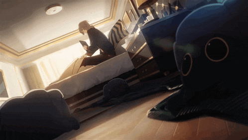 a man sits on a bed in a bedroom looking at his phone
