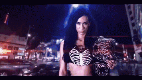 a woman in a skeleton costume is standing in a city at night