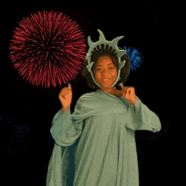 a woman in a statue of liberty costume dancing in front of fireworks