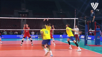 a group of volleyball players are playing a game on a court with a volleyball net