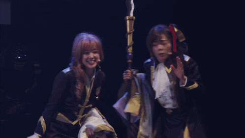 two girls are dancing on a stage and one has a medal on her chest that says ' a ' on it
