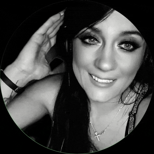 a black and white photo of a woman wearing a cross necklace .