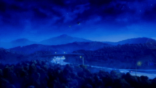 a bridge over a highway with mountains in the background