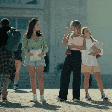 a group of girls are standing in front of a building that says ' anna ' on it