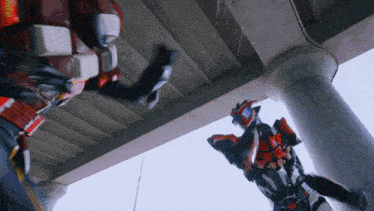 two robots are fighting under a bridge and one of them has a red belt that says ' a ' on it