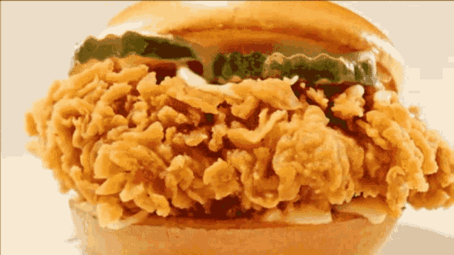a close up of a fried chicken sandwich with a pickle on top