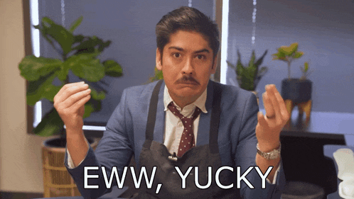 a man in a suit and tie says eww yucky in front of a plant