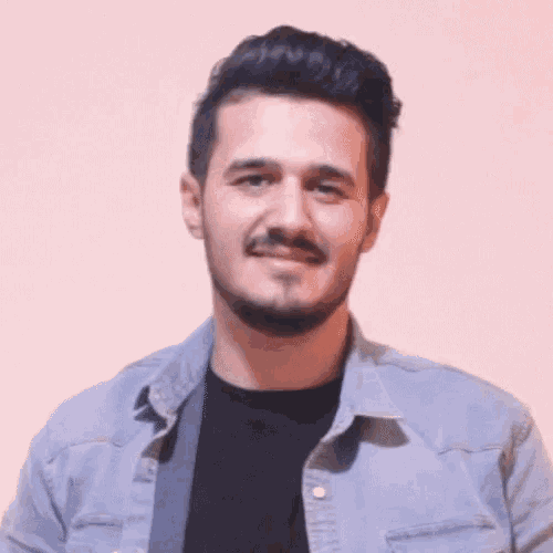 a man with a beard and mustache is wearing a blue denim shirt and a black shirt .