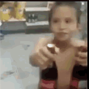 a young boy is holding a bottle of coca cola in his hand .