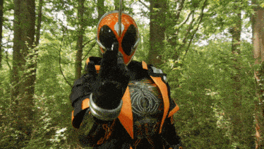 a man in a superhero costume is standing in the woods and giving the middle finger