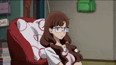 a girl with glasses sits in a chair with a pillow