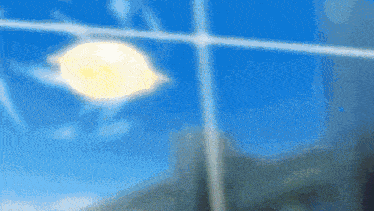 a blurry picture of a blue sky with the sun shining through the window