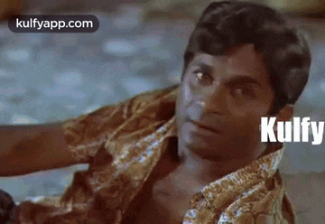 a man in a shirt is laying on the floor with the word kulfy written on his shirt .