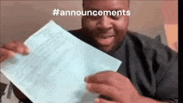 a man is holding a piece of paper in his hands and laughing .