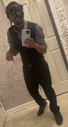 a man in a suit is taking a picture of himself in the mirror