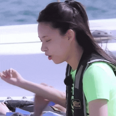a woman wearing a life vest is sitting on a boat .