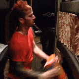 a man in a red shirt is playing a guitar