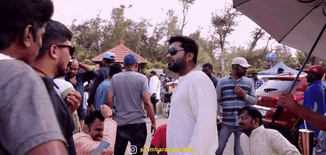 a group of men are gathered in a parking lot with a watermark that says ' sambararam ' on it