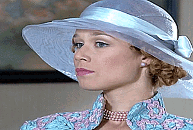 a woman wearing a hat and a choker is looking to the side