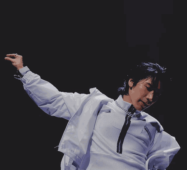 a man in a white shirt with a choker around his neck is dancing