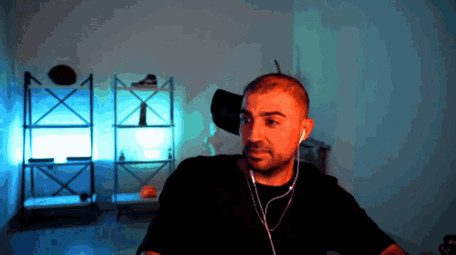 a man wearing earbuds looks at the camera
