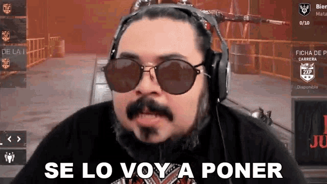 a man wearing headphones and sunglasses is making a funny face .