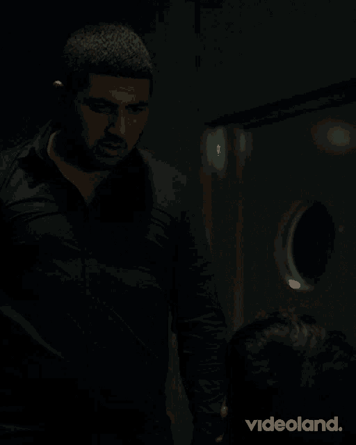 a blurred image of a man holding a gun with videoland written on the bottom right