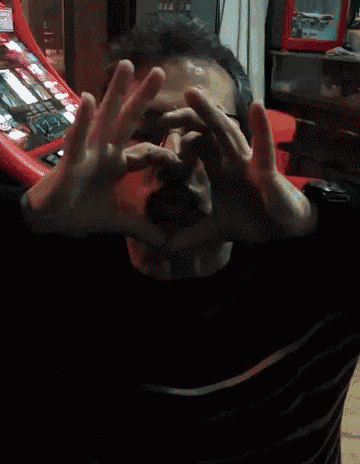 a man covering his face with his hands in front of a machine