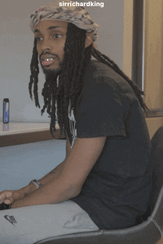 a man with dreadlocks sits in a chair with the name sirrichardking above him