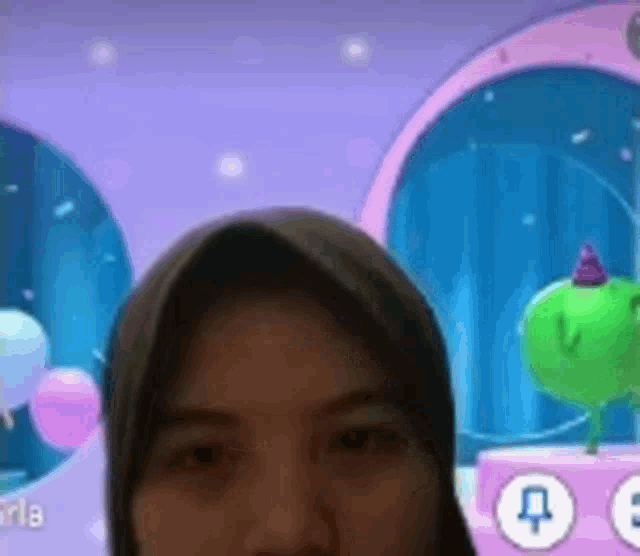 a woman wearing a hijab is looking at the camera in front of a screen with balloons on it .