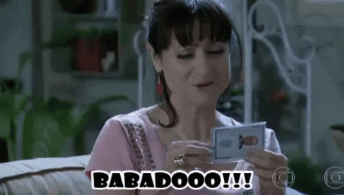a woman is sitting on a couch holding a card that says babadoo