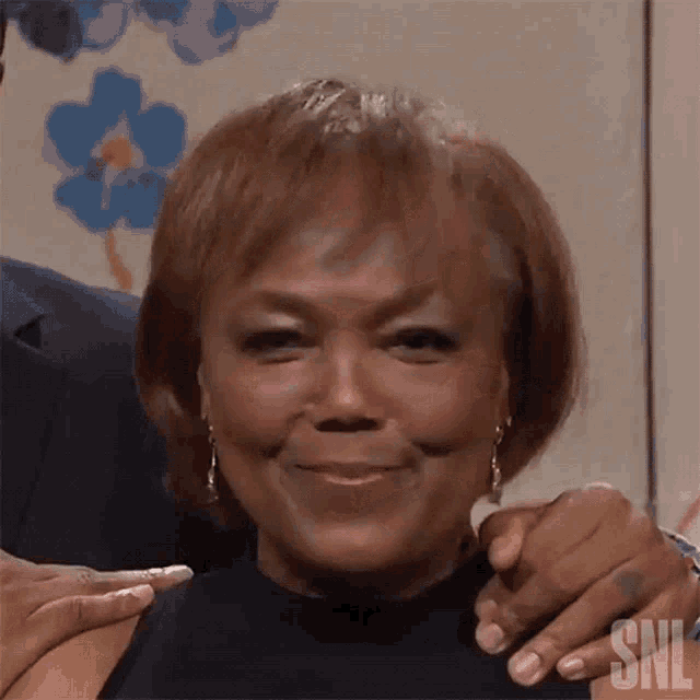 a close up of a woman 's face with the letters snl on the bottom