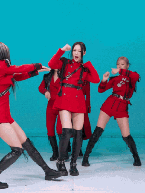 a woman in a red dress and black boots is surrounded by other dancers