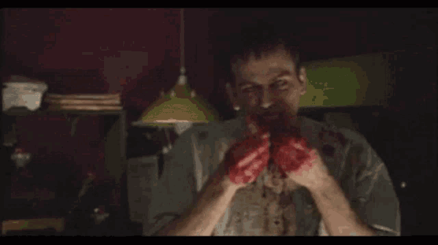 a man with blood coming out of his mouth is eating a piece of meat