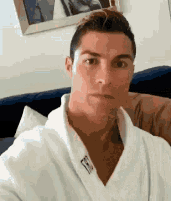 a man wearing a white robe with the letter t on the collar