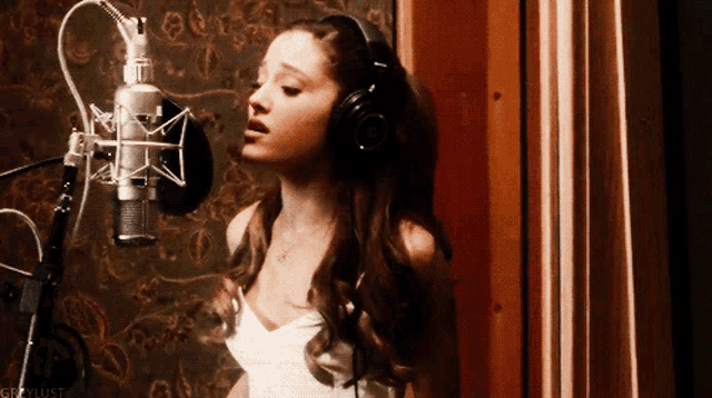 a woman wearing headphones is singing into a microphone with the hashtag crazylust visible in the corner
