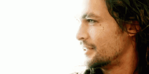 a close up of a man 's face with a beard .