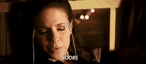 a woman is wearing headphones and saying `` boobs '' .