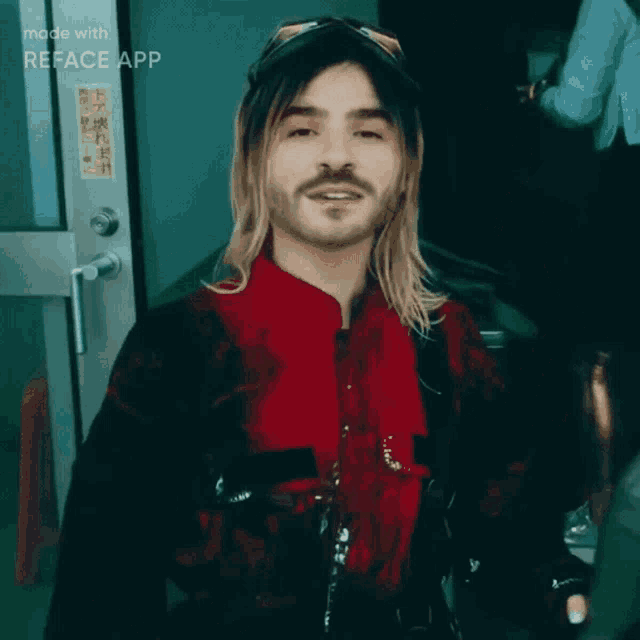 a man with long blonde hair and a beard is wearing a red jacket