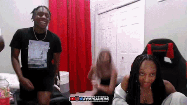 a man and a woman are dancing in a room with red curtains