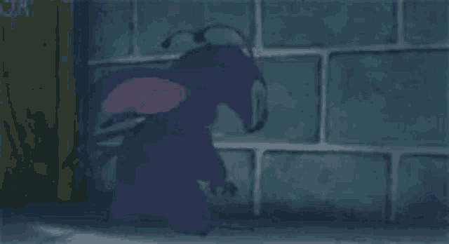 a purple cartoon character is standing next to a wall .