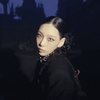 a woman in a black jacket holds a sword in her hand