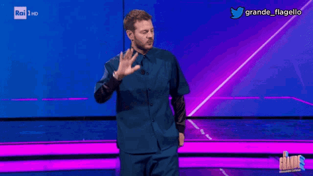 a man in a blue shirt is standing in front of a purple background and says twitter e impazzito