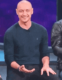 a bald man wearing a black polo shirt is clapping