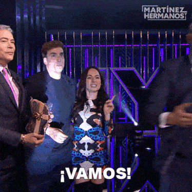 a group of people standing in front of a martinez hermanos logo