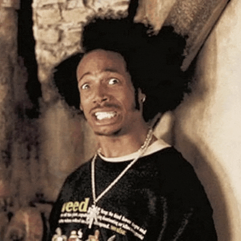 a man with a afro is wearing a black shirt that says reed on it .