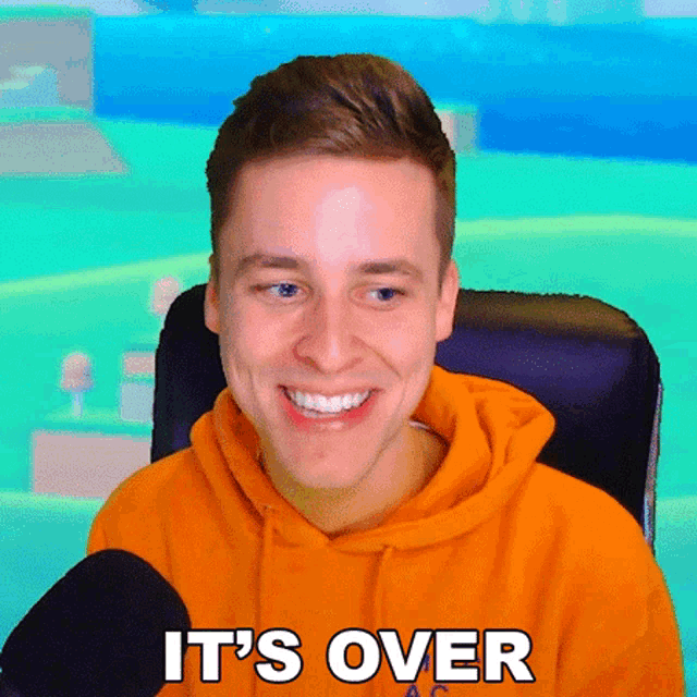 a man in an orange hoodie says it 's over while smiling