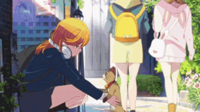a girl with headphones is petting a cat while walking down a sidewalk .