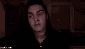 a man with long hair is making a funny face and pointing at the camera while saying `` with penises '' .