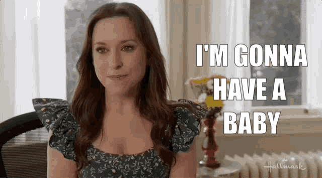 a woman sitting in front of a window with the words " i 'm gonna have a baby " on her face
